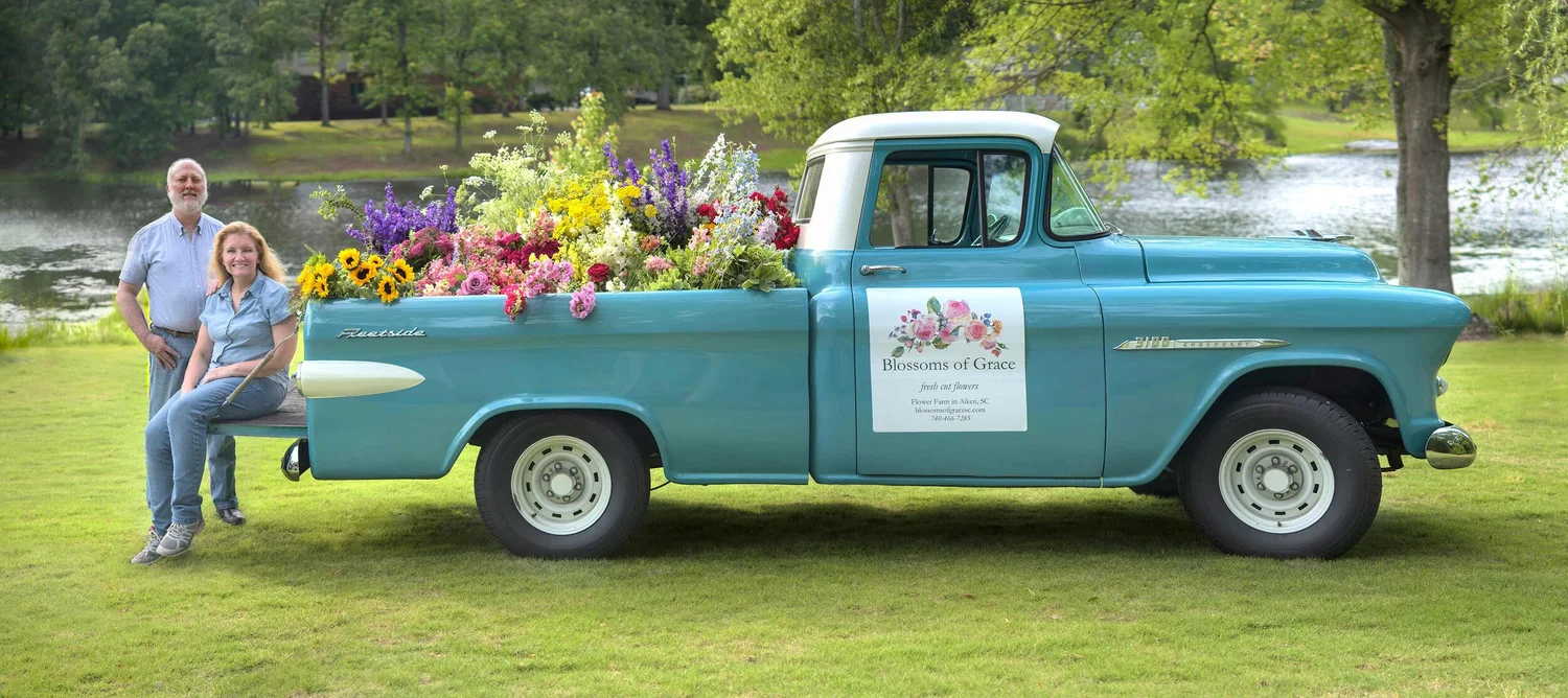 The classic Blossoms of Grace pickup truck loaded with fresh flowers by the lake